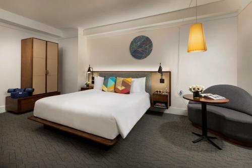 a bedroom with a large bed and a chair at Hotel Seville NoMad - The Unbound Collection by Hyatt in New York