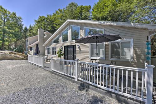 a house with an umbrella on the front porch at Fire Pit and Furnished Deck Serene Tobyhanna Escape in Tobyhanna