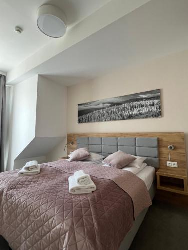 a bedroom with a bed with two towels on it at Aparthotel Apartamenty Czarna Góra 417 in Sienna