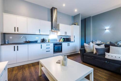 a kitchen and living room with a couch and a table at Versace Inspired Apartment in Liverpool