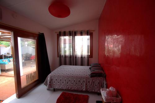 a red bedroom with a bed and a window at Zurisadai in Puerto Ayora