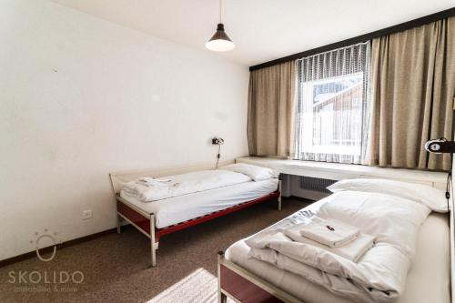two beds in a room with a window at Haus Camillo in Saas-Fee
