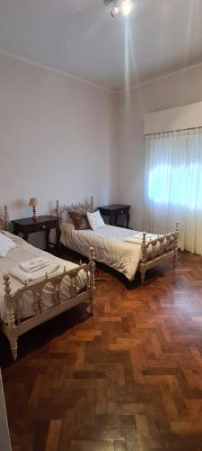 two beds in a room with wooden floors at Hermoso Dpto. en el Corazón de Salta Capital in Salta