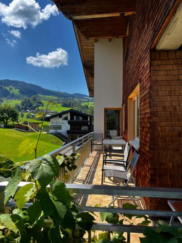 a balcony of a house with chairs and a view at Wiesen Appartment in Schwarzenberg im Bregenzerwald