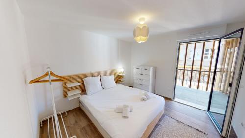 a bedroom with a white bed and a large window at Au Pied Du Mont 1 free parking in Obernai