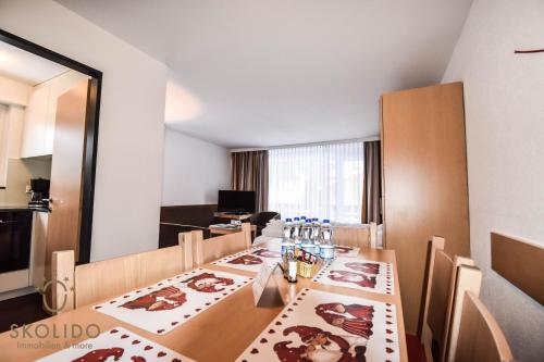 a dining room with a table and a room with a kitchen at Haus Camillo in Saas-Fee