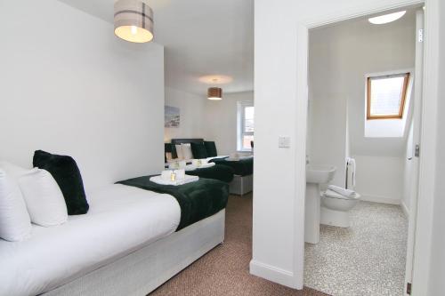 a bedroom with a bed and a bathroom with a toilet at Canalview House - 7Bed City Gem, Free Driveway Parking, Netflix, TVs in All Bedrooms in Coventry