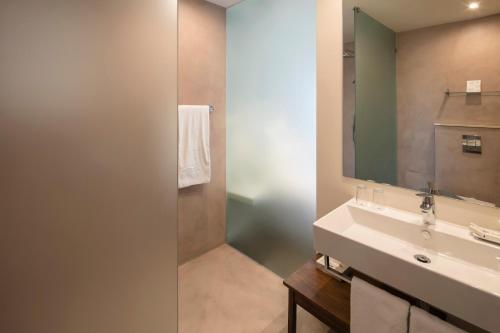 a bathroom with a sink and a mirror at Costa d'Oiro Ambiance Village in Lagos