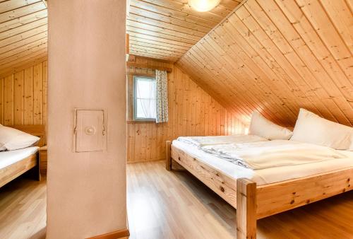 a bedroom with two beds in a wooden house at Chalet Mariedl in Schruns-Tschagguns