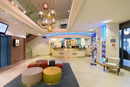 a lobby of a store with a couch and chairs at Studios Astra Hotel Vevey in Vevey