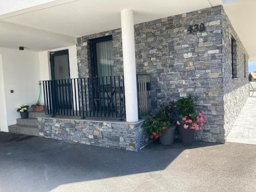 a brick house with two potted plants and a balcony at Hotel Apart Piz Mundin in Kappl