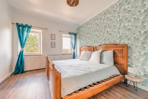 a bedroom with a wooden bed with blue curtains at Havre de paix au pied du château et des remparts in La Petite-Pierre