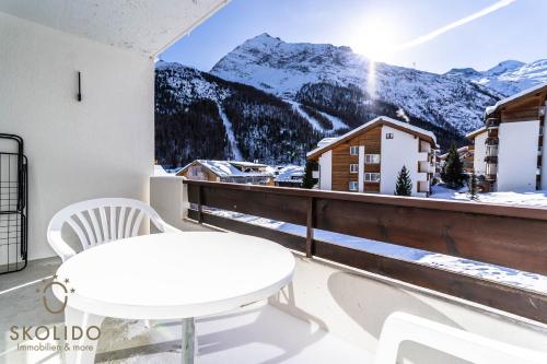 a balcony with a table and a view of a mountain at Haus Camillo in Saas-Fee