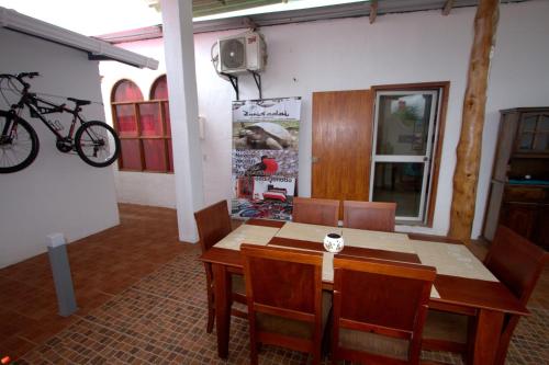 a dining room with a table and a bike on the wall at Zurisadai in Puerto Ayora