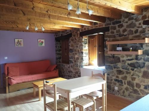 ein Wohnzimmer mit einem Sofa und einem Tisch in der Unterkunft Casa Rural La Barcenilla in Herada