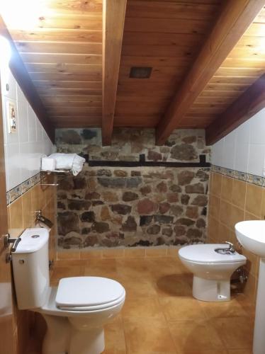 a bathroom with a toilet and a sink at Casa Rural La Barcenilla in Herada