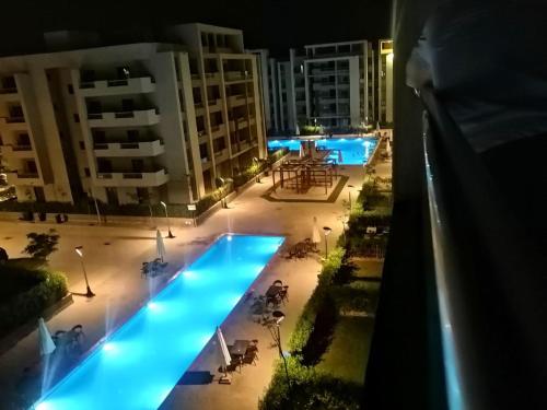 a view of a swimming pool at night at قرية جراند هيلز in ‘Izbat Nādī aş Şayd