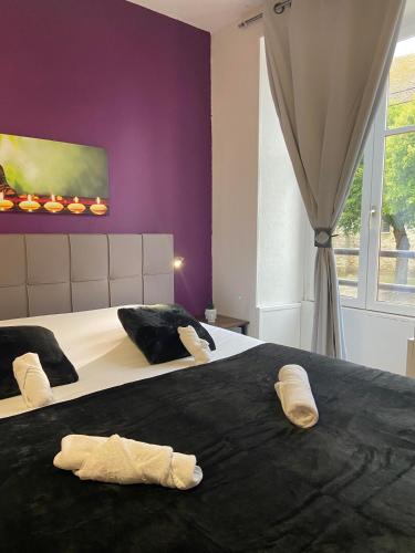 Dos camas en un dormitorio con dos pares de toallas. en Hôtel du Cerf en La Guerche-sur-lʼAubois