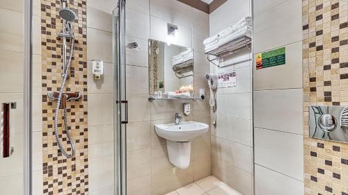 a bathroom with a shower and a sink and a toilet at St Lukas Medical & SPA in Świeradów-Zdrój