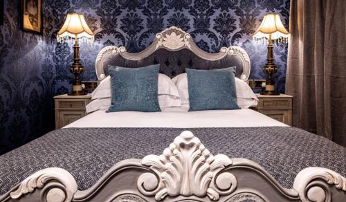 a bedroom with a large bed with blue wallpaper at Melville Castle Hotel in Edinburgh
