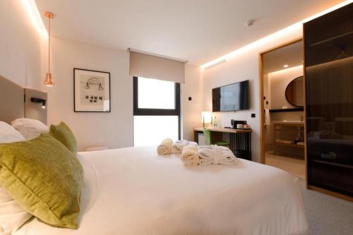 a bedroom with a white bed with towels on it at Protur Naisa Palma Hotel in Palma de Mallorca