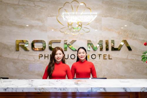 two women standing at a table in front of a sign at Rockmila Hotel in Phu Quoc