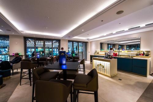 a restaurant with tables and chairs and a bar at Studios Astra Hotel Vevey in Vevey