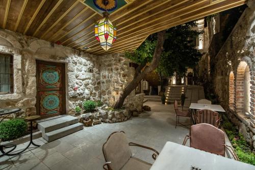 a patio with a table and chairs and a chandelier at Foremanson Cave Hotel in Nar