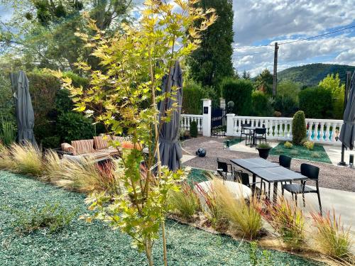 a garden with a table and chairs and a tree at LA VILLA Hôtel-Restaurant in Saverne