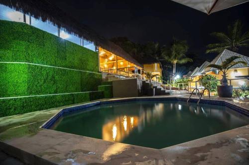 a swimming pool in front of a house at night at Hotel Morro De São Paulo in Morro de São Paulo