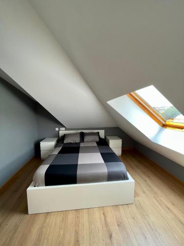 a bedroom with a black and white bed in a attic at Villa Churiana in Camariñas