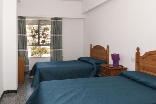 a bedroom with two beds and a window at Montemar, C-12º-33 in Cullera
