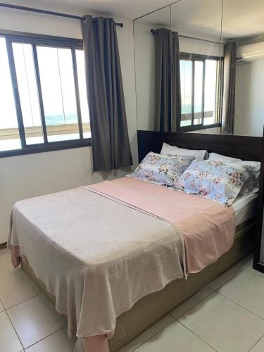 um quarto com uma cama grande e janelas em Praia Dourada SUITE PREMIUM 603 Itaparica em Vila Velha