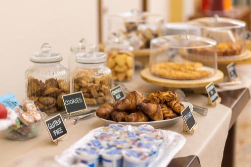a table with various types of pastries and jars of food at Villa Santa Margherita - B&B in Cortona