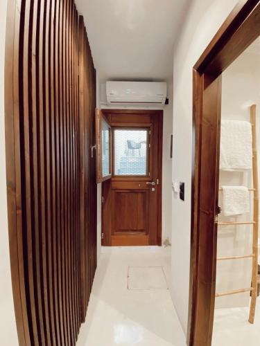 a hallway with a wooden door and a window at Archo Suites Pythagoreio in Pythagoreio
