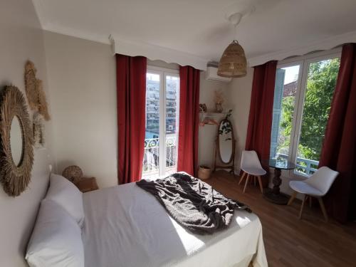 - une chambre avec un lit blanc et des rideaux rouges dans l'établissement Chambre privée luxueuse Villa Monte 0ropa, à Nice
