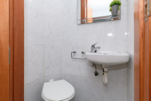 a white bathroom with a toilet and a sink at Rentalmar Family Felix con parking incluido in Salou