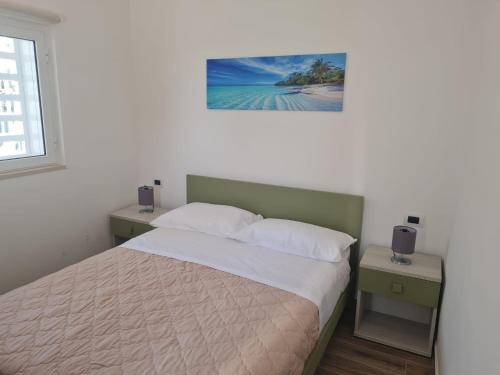 ein Schlafzimmer mit einem Bett und einem Bild an der Wand in der Unterkunft Scauri Rooms B&B in Minturno