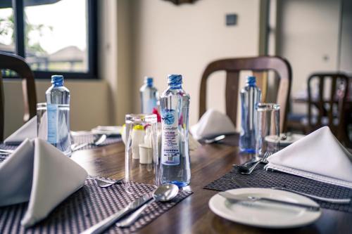 a wooden table with blue bottles on top of it at Hotel Comster Mtwapa in Mtwapa