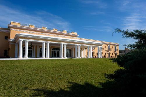 a large building with a lawn in front of it at Hotel Colonial San Nicolás in San Nicolás de los Arroyos