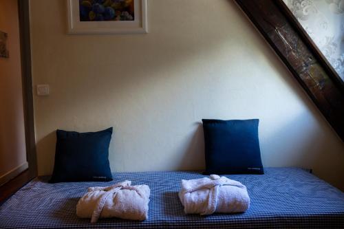a bed with two towels on top of it at La demeure aux Pins in Lourdes