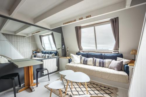 un salon avec un canapé et une table dans l'établissement Le Nid de Juno Beach - Vue mer - Plage à 350m, à Courseulles-sur-Mer