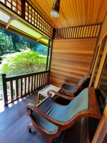 a room with chairs on a porch with a large window at HOTEL BESAR BULAN BARU - Senggigi in Senggigi 