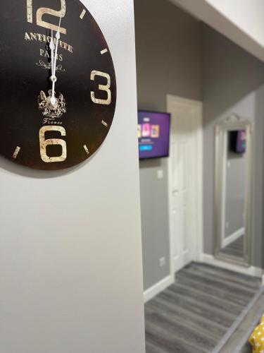 a clock hanging on a wall in a hallway at Grays Accommodation B&B in Grays Thurrock
