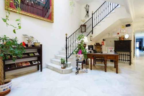 uma grande sala de estar com uma mesa e escadas em Hostal Ciudad Trigueros em Trigueros