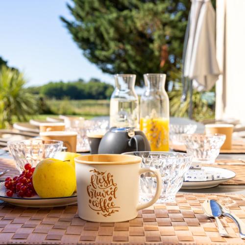 a table with cups and plates of food on it at Pomme de Reinette in Azay-le-Rideau