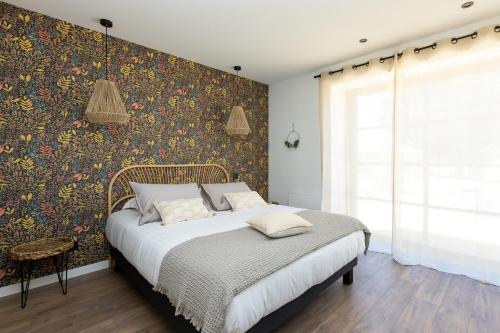 a bedroom with a bed with a floral wallpaper at Pomme de Reinette in Azay-le-Rideau