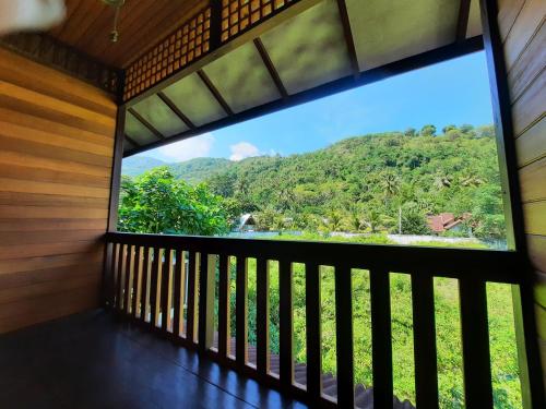 a window in a room with a view of a mountain at HOTEL BESAR BULAN BARU - Senggigi in Senggigi 