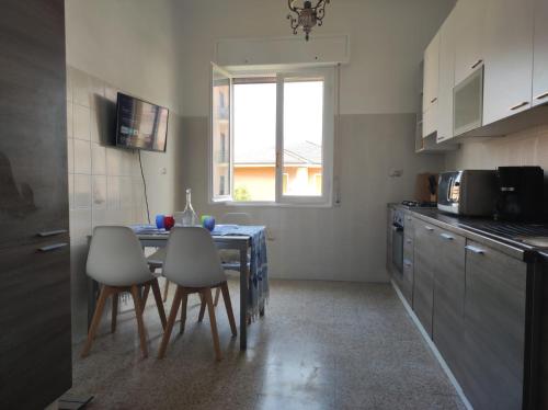 リーヴァ・リーグレにあるAppartamento vicino al mare con parcheggioのキッチンにテーブルと椅子がある