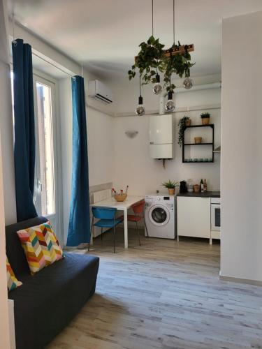 een woonkamer met een bank en een tafel en een keuken bij Dea Dreams APARTMENT Piazzale Lodi Wi-Fi Metro a 2 passi in Milaan